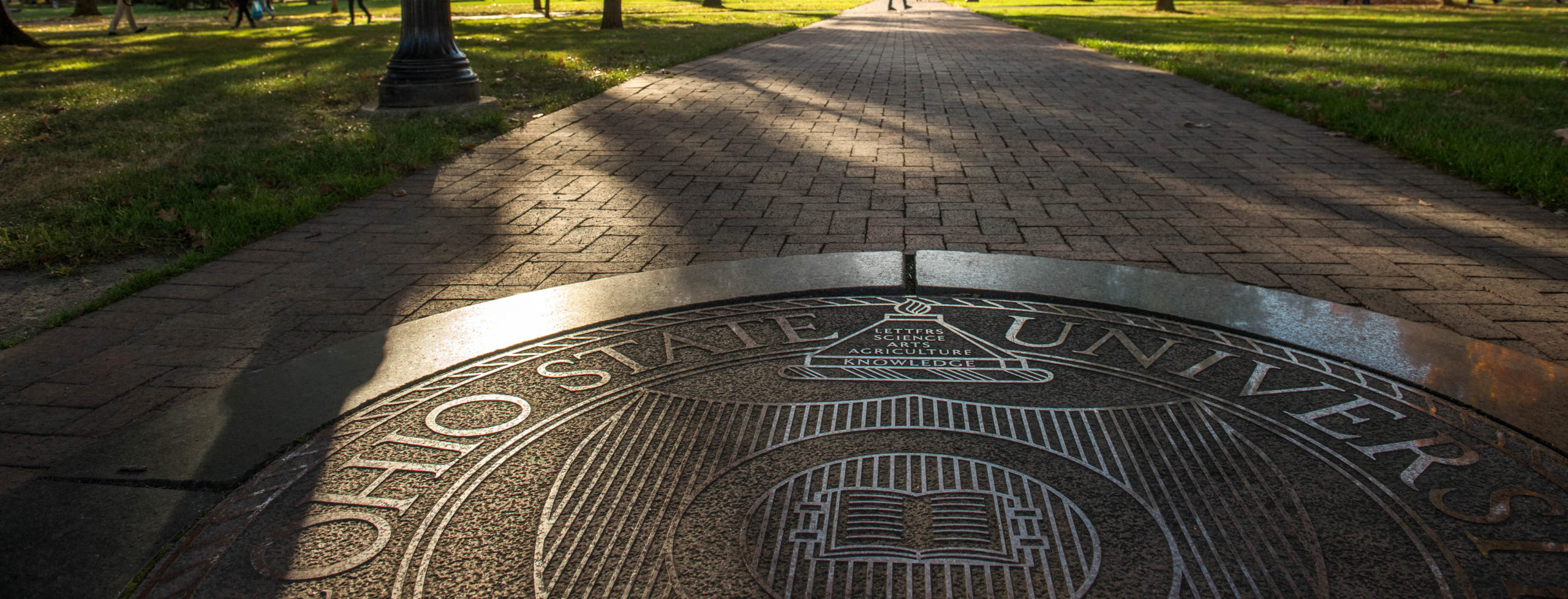 The Ohio State University crest emblazoned on a walkway through OSU's wooded Lincoln Tower Park